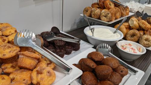 A photo of a catered table of muffins and bagels.