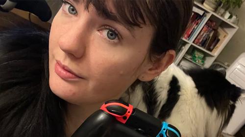 Anna Webster, a game controler, and a cat