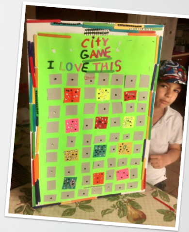 A photo of Osama's son posing in front of his board game "City Game I Love This"