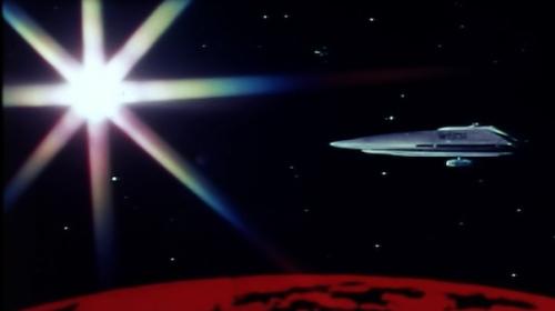 A screenshot from the 1974 film "Dark Star," showing a gray spaceship orbiting a red planet with a large shining star in the background.