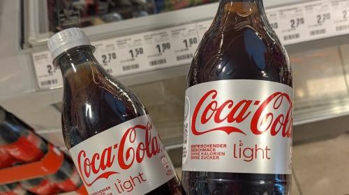 A hand (Mark's) holding two 500ml bottles of "Coca-Cola Light."