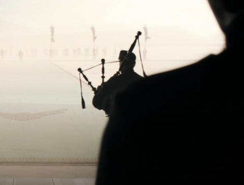 A screenshot from Dune (2021) depicting a bagpipe player descending a ramp.