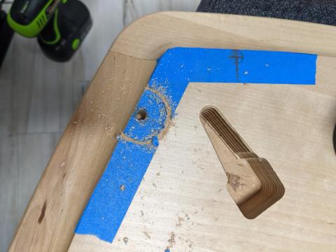 A photo of a partially-drilled hole underneath a table.