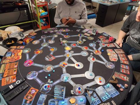Photo of a complex board game (Star Trek: Ascendancy) spread out across a tabletop. The game has many different pieces, cards, and connecting pathways made of cardboard.