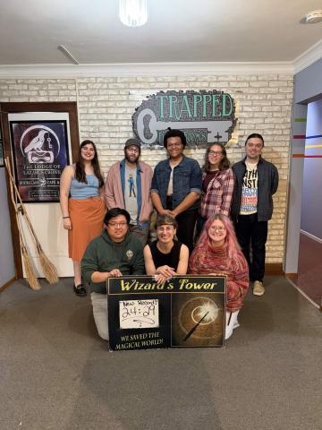 A picture of Lydia, Mark, Dale and friends after finishing a puzzle room.