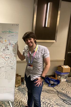 A picture of Trenton Greyoak next to a map created during play of Deephaven.